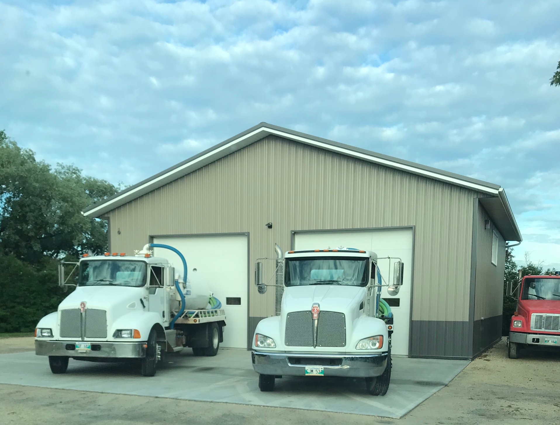 Macdonald Septic trucks at the shop in summer